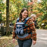 Parent wearing a plus-size baby carrier in a park in Pennsylvania.